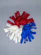 Three colors of deflated latex balloons white blue red on a gray background