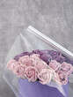 A roll of transparent packaging film and a bouquet of roses in a box on the table