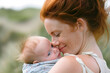 © Алина Троева - Fashion portrait redhead freckles mother holds hugs newborn baby at nature, Mother's Day concept.