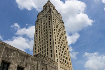 Wall Mural - The Louisiana State Capitol building with lush green trees, blue sky and clouds in Baton Rouge Louisiana USA
