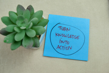 Wall Mural - Concept of Turn Knowledge Into Action write on sticky notes isolated on Wooden Table.