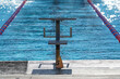 a swimming diving block next to the pool isolatied outdoors at a competitive pool