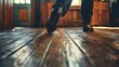 Person walking on wooden floor in sunlight, close-up feet