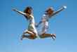 Happy girls jumping against the sky