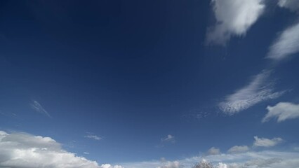 Wall Mural - time lapse fast moving white clouds and blue sky.