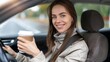 © JovialFox - lifestyle and people concept - happy smiling young woman or female driver driving car and drinking takeaway coffee
