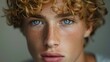 male model with short curly hair cut, looking at camera, blond reflexes in hair