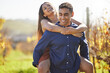 © peopleimages.com - Man, woman and piggy back at vineyard for smile, walking and playful with connection in summer. Happy couple, hug and excited on adventure in countryside, wine farm and nature with love on holiday