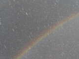 Fototapeta  - Rainbow on dark sky background during a hailstorm