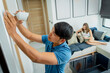 © romaset - A technician installs a CCTV camera in a modern apartment.