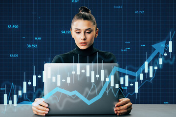 Canvas Print - Attractive young european woman at desk using laptop with creative blue candlestick forex chart and growing arrow on blue background. Trade, finance and stock concept.