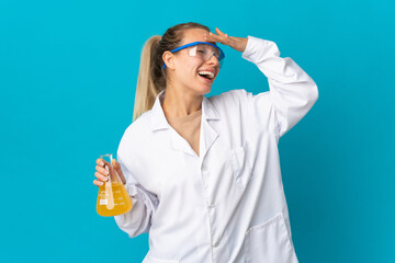 Wall Mural - Young scientific woman isolated on blue background smiling a lot