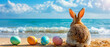 Back view of a bunny beside Easter eggs on a sandy beach.