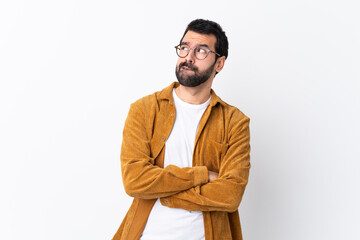 Wall Mural - Caucasian handsome man with beard wearing a corduroy jacket over isolated white background with confuse face expression