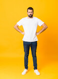 Fototapeta Na drzwi - Full-length shot of man with beard over isolated yellow background angry