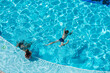 kids swimming in pool underwater.