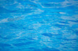 Swimming pool bottom caustics ripple and flow with waves background. Summer background. Texture of water surface. Overhead view.