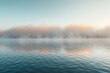 Dense fog rolling over a tranquil lake at sunrise.