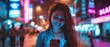 Young beautiful woman using her smartphone on a city street full of neon lights in the evening. Portrait of a gorgeous smiling female using her mobile phone.