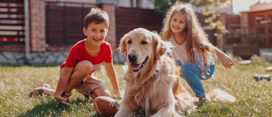 On the backyard lawn, two kids are having fun with their handsome golden retriever dog. They pet, play, tackle and scratch. Happy dog has a toy football in his jaws. Suburb house in summer.