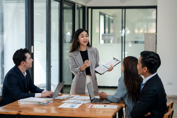 Female business leader presenting graphs to team. Leadership and business strategy concept.