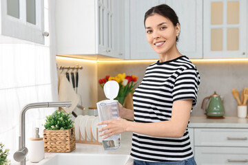 Sticker - Woman holding filter jug with water in kitchen