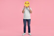© New Africa - Man covering face with smiling emoticon on pink background