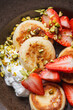 Cottage cheese pancakes or syrniki with strawberries, sour cream and pistachios.