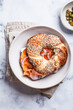 Breakfast bagel with salmon, cream cheese, capers and onions, white background.