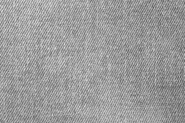 Fototapete - A close up of a piece of denim fabric with a lot of texture. The fabric is a light grey color and has a worn look to it