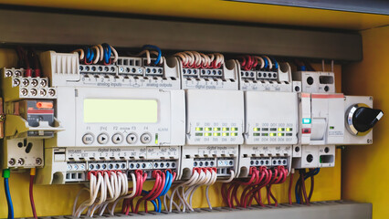 Wall Mural - A panel of electrical wires with a green light on it. The wires are connected to a yellow box