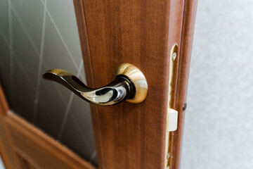 Sticker - Close up of a varnished hardwood door handle on a wooden door