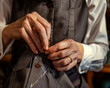 Hyper-realistic half-body shot of a female tailor fitting a garment, her careful hands and concentrated beauty in focus.