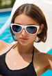 Beautiful and attractive young woman with sunglasses and bikini by the swimming pool. Close up portrait.