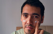 © JulioCsar - portrait of latin man applying moisturizer on his face