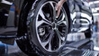 A person is touching the tire of a car on an assembly line, AI