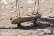 A swing standing on the sea sand. Oceanside swing made from driftwood sea logs. Vintage swing standing in the sand on the seashore.
