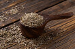 Pile of anise spice isolated on wooden spoon. Aromatic dry anise seeds on a dark wood background. Anise seeds on wooden spoon.