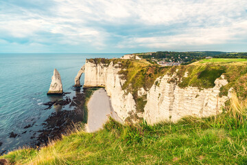 Wall Mural - White chalk cliffs and natural arches Aval and Needle of Etretat and beautiful famous coastline during low tide, Normandy, France. French sea coast in Normandie with famous rock formations at sunset