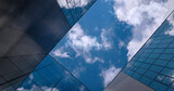 Fototapeta  - Up view between glass metal office buildings, corporation business skyscrapers, clouds sky. Looking up at modern downtown financial office architecture. City real estate background, minimalist design