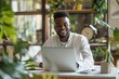 © Olexiy Vasilyuk - Portrait of smiling male IT professional sitting at desk with laptop and taking notes in modern office, copy space for text banner stock photo concept. Smiling young man working on computer using