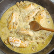 morceaux de poulet, sauce champignons, en cuisson dans une poêle.	