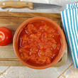 bol de tomates concassées, en gros plan, sur une planche à découper	