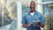© MP Studio - Smiling Doctor Holding Tablet