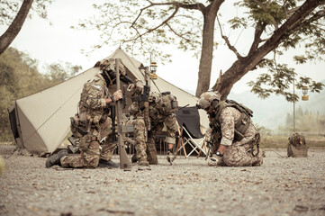 Wall Mural - Soldiers in camouflage uniforms planning on operation in the camp, soldiers training in a military operation