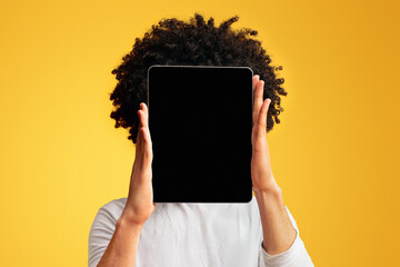 Wall Mural - Young man hiding his face behind digital tablet