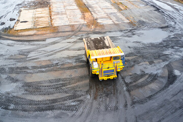 Wall Mural - A quarry dump truck is driving on a dirty road. Top view