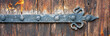 Rusty old door hinge close-up. Forged hinge on an old wooden door. A weather-beaten door made from weathered old boards.