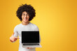 Smiling hipster pointing finger on blank laptop screen