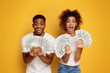 Shocked and happy black guy and girl holding lots of money